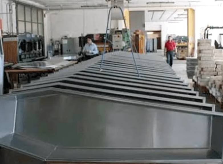 Reparto produttivo con movimentazione di un cofano in zinco