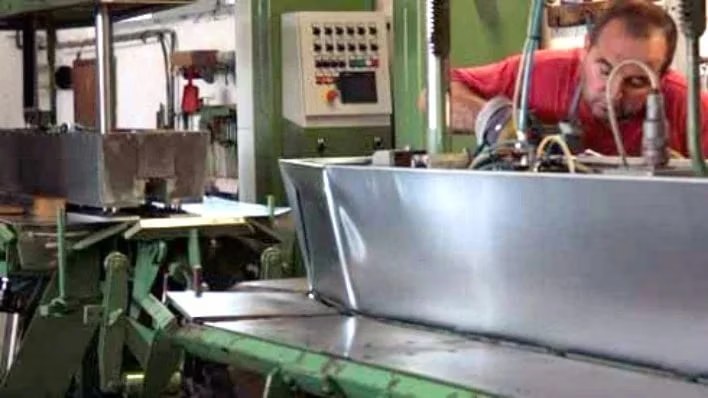 Operatore specializzato al lavoro su una linea di piegatura della lamiera di zinco